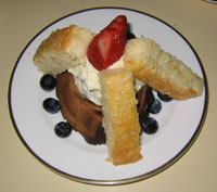 A White Chocolate Hazelnut Mousse served a top a Chocolate Meringue Base and accompanied by fresh sponge soaked in a Hazelnut Syrup and fresh berries.